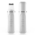 Pore cleansing facial device in golden finish with metal head, resting on a surface with USB cable