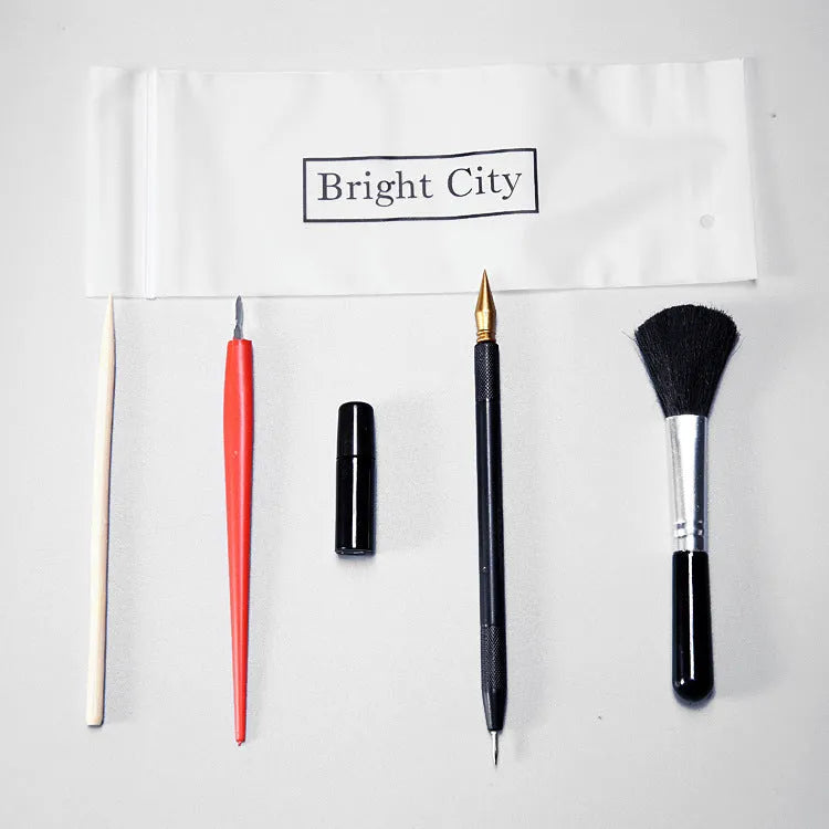 Scratch art repair tool set with scraping pen, liquid solution, brushes, and bamboo sticks on a craft table.