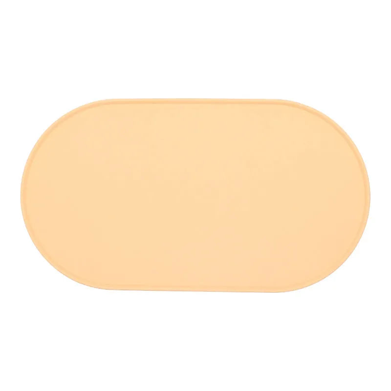 A green silicone placemat for cat food and water bowls on a wooden floor.