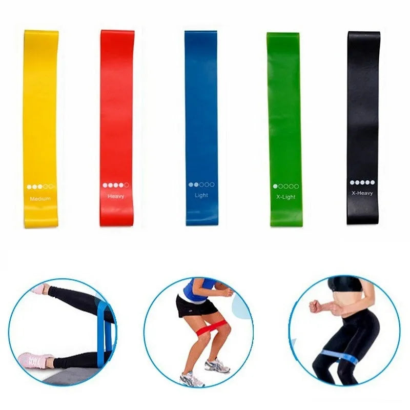 Set of five coloured TPE yoga tension straps for fitness training laid flat showing green, blue, yellow, red, and black.