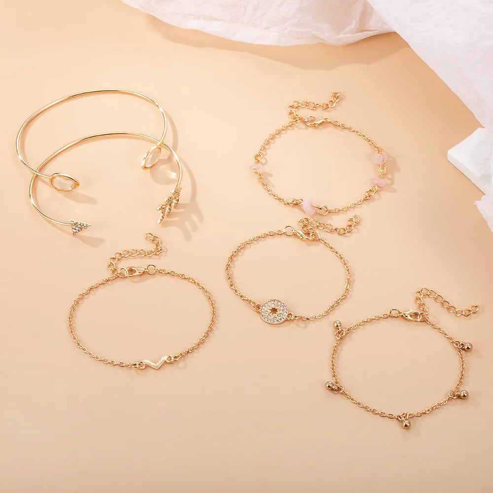 Gold-coloured zinc alloy bracelet set with arrow and V-shaped water droplet design elements
