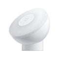 White cube-shaped Mijia bedside night light with motion sensor and Bluetooth on a wooden table.