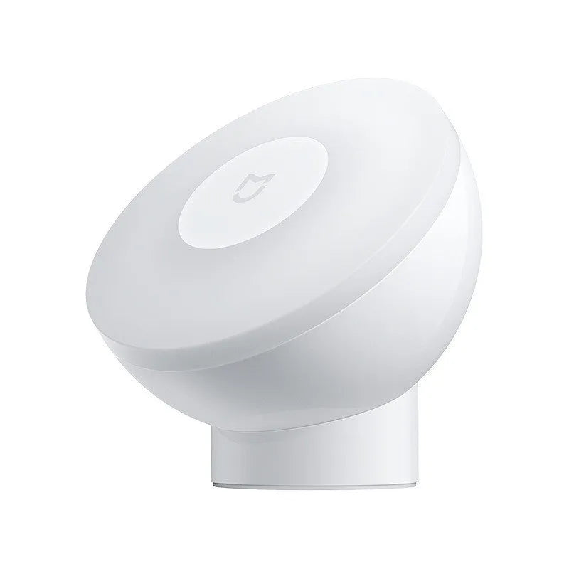 White cube-shaped Mijia bedside night light with motion sensor and Bluetooth on a wooden table.