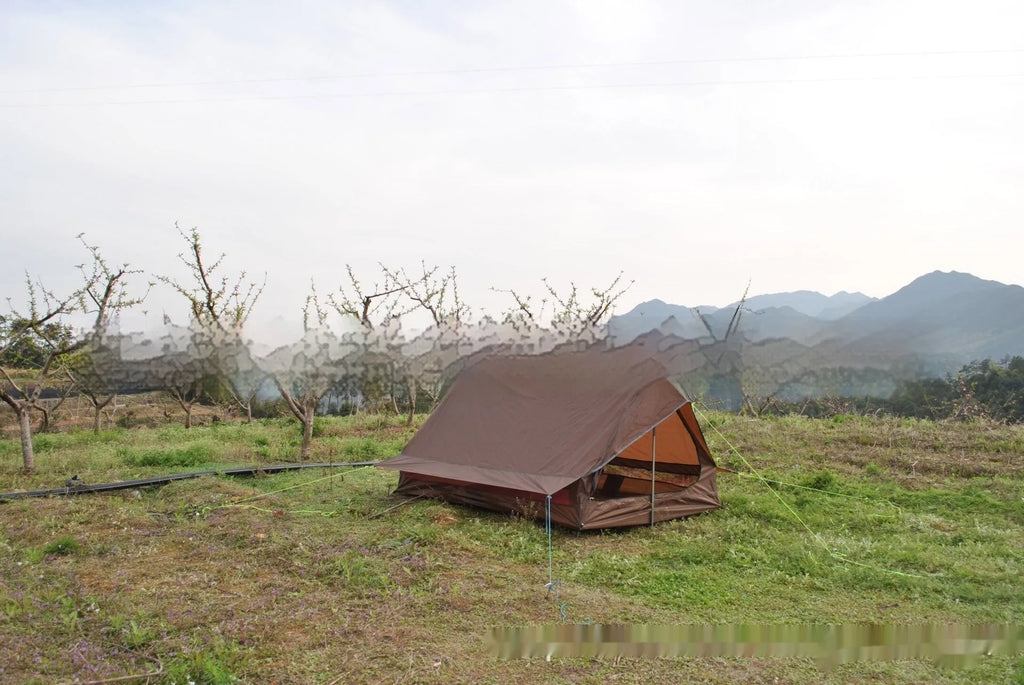Brown A-line cabin tent pitched using hiking poles with aluminium ground nails and fluorescent wind ropes