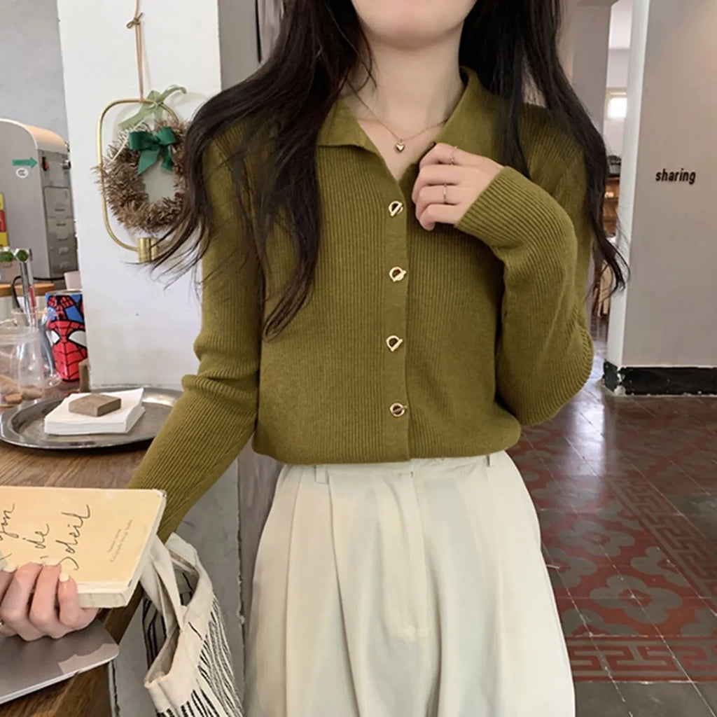 A woman wearing a loose-fit, long-sleeved knitted cardigan in a beige colour, showcasing its drape and cardigan style.