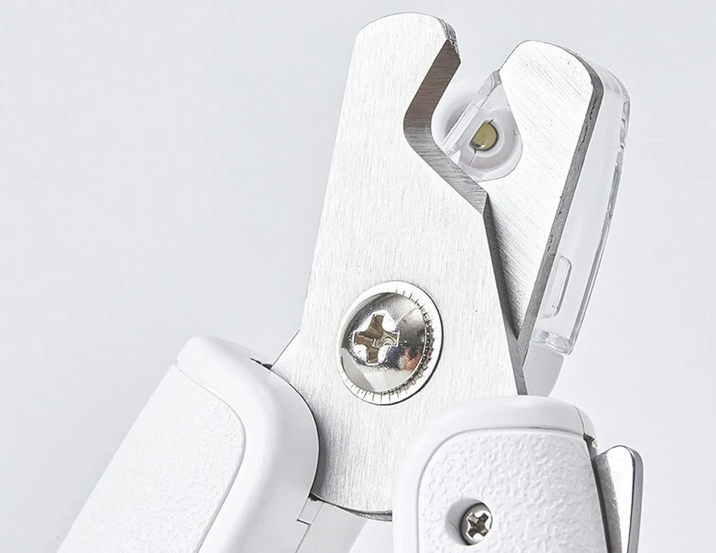 White pet nail clippers with built-in LED light and transparent anti-splash guard.