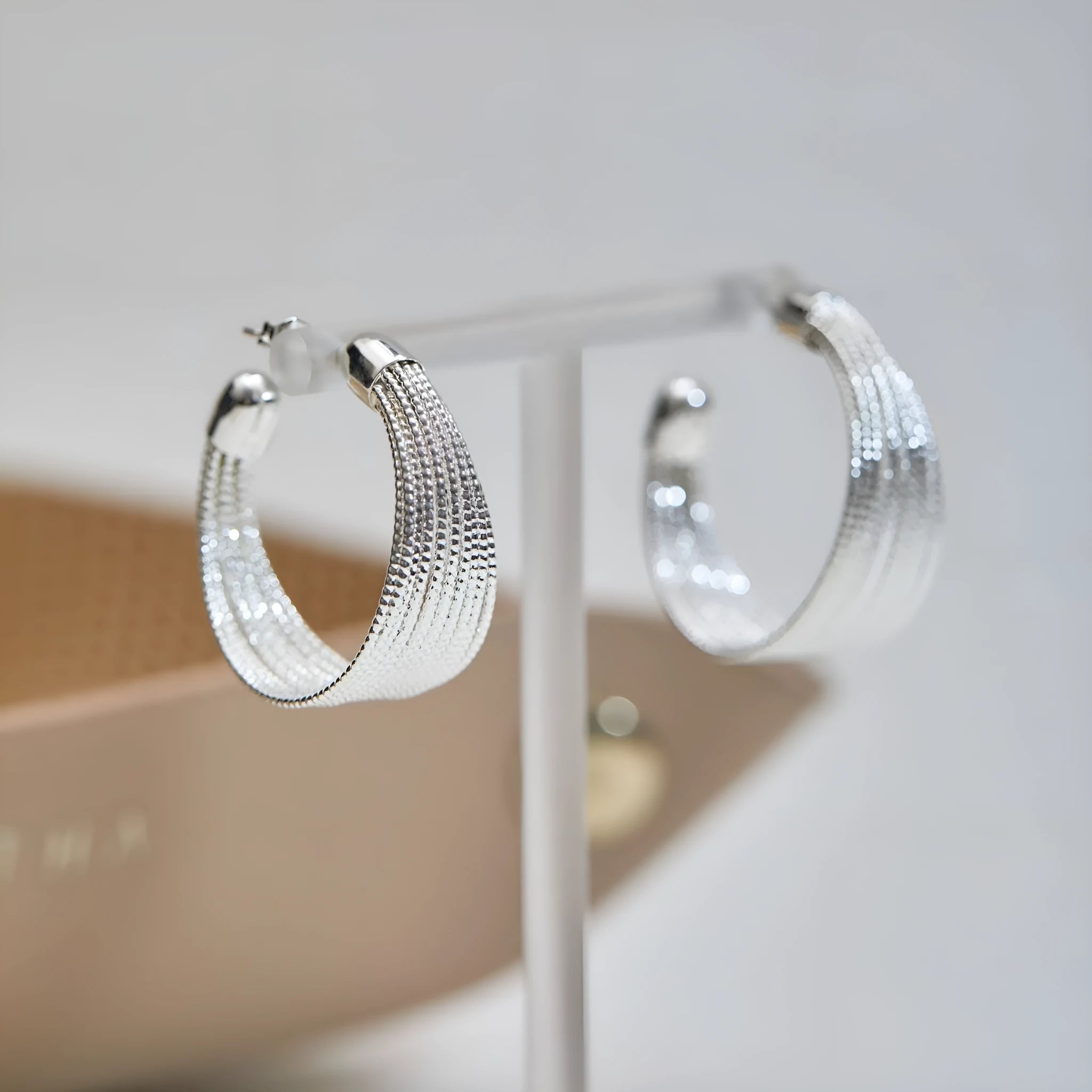 Set of geometric multi-layer earrings in gold and silver, showing stud and clip styles on a flat surface.