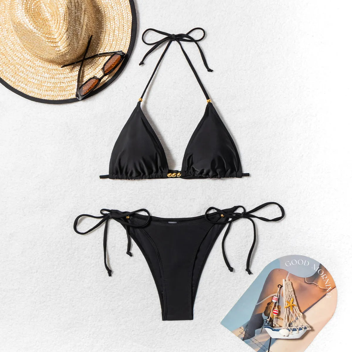 Black women's bikini swimsuit with metal bead decoration on a split-style design.
