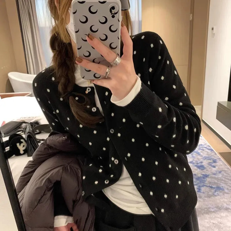 Women's grey dot pattern knitted cardigan with crochet flower detailing on mannequin