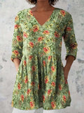 A woman wearing a loose, printed dress with 3/4 sleeves and a wide waist, available in multiple sizes.