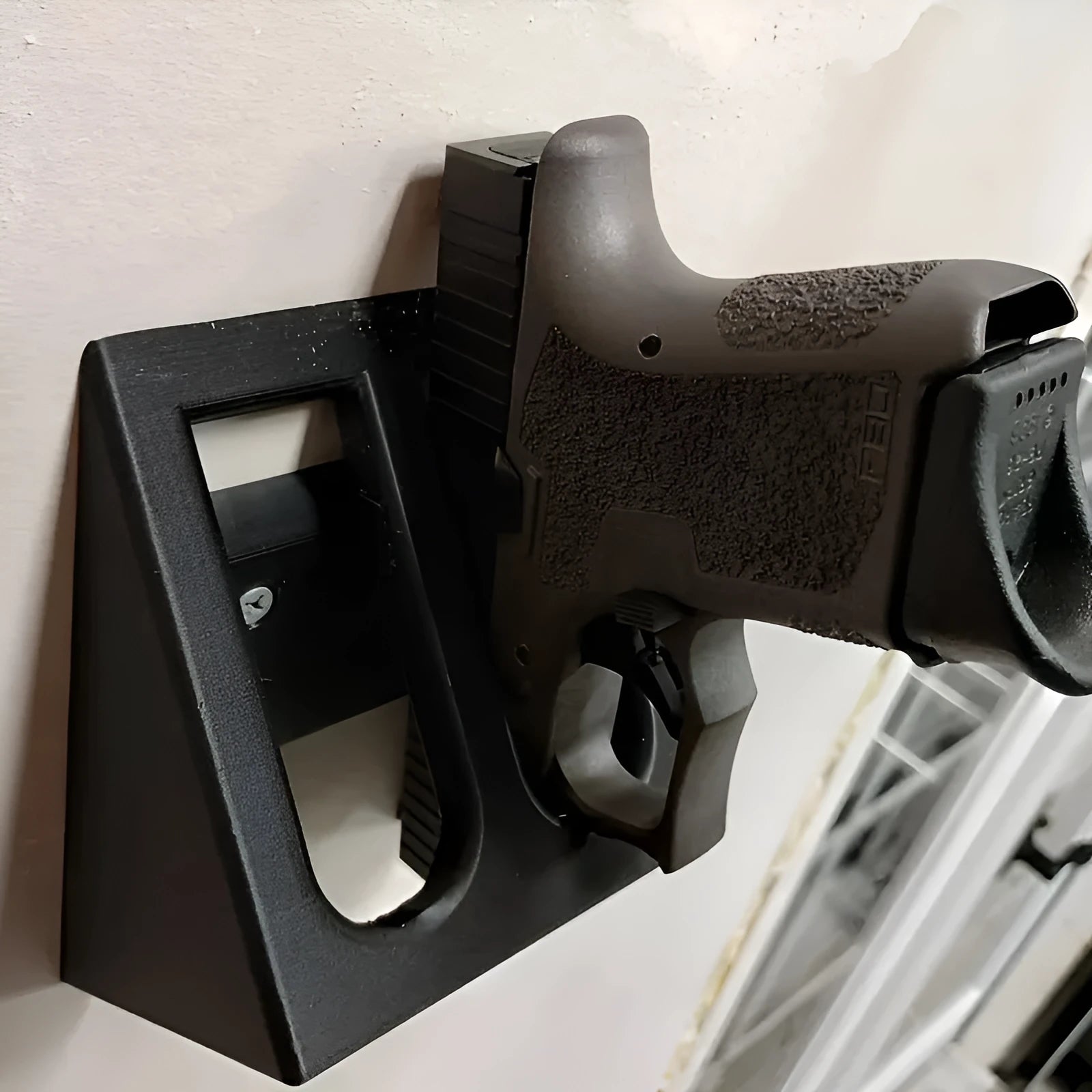Black punk-style plastic pistol stand measuring 10.85 by 7.6 centimetres