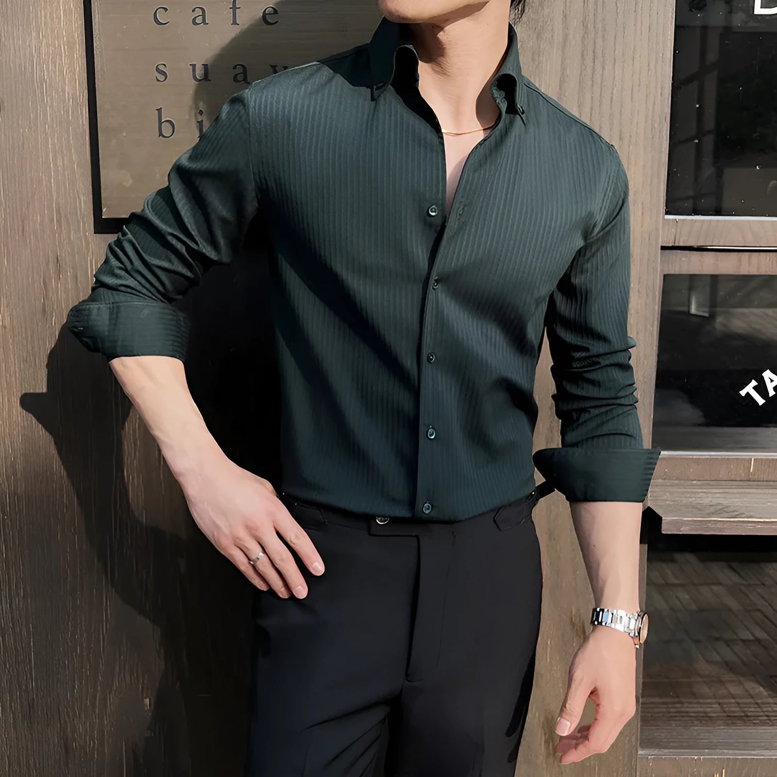 Man wearing a dark striped V-neck long sleeve casual shirt in a cardigan style.