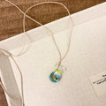 Women's skirt and joker charm pendant necklace with coloured glass on a cotton linen clavicle chain.