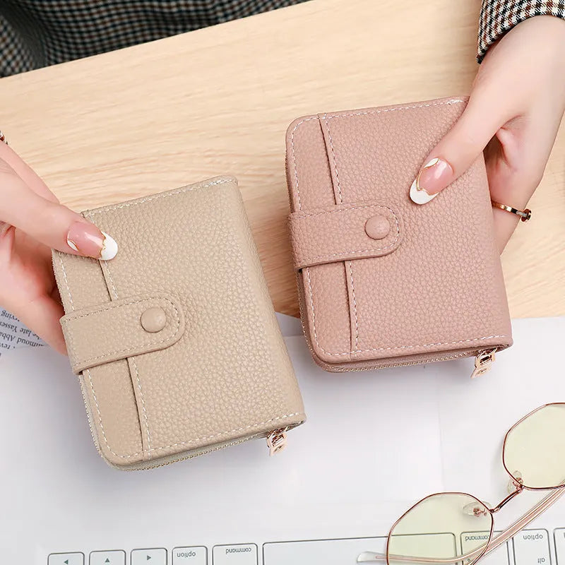 Beige ladies short wallet with a textured lychee pattern, shown in a two-fold open position.