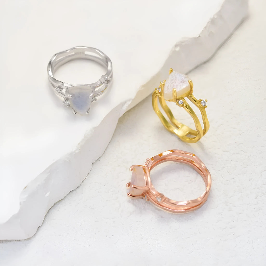 S925 sterling silver ring with irregular triangle design holding a moonstone, shown in rose gold plating.