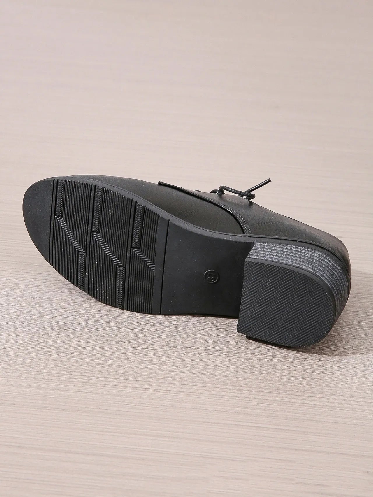 Black women's low top work shoes with a short chunky heel and pointed toe.