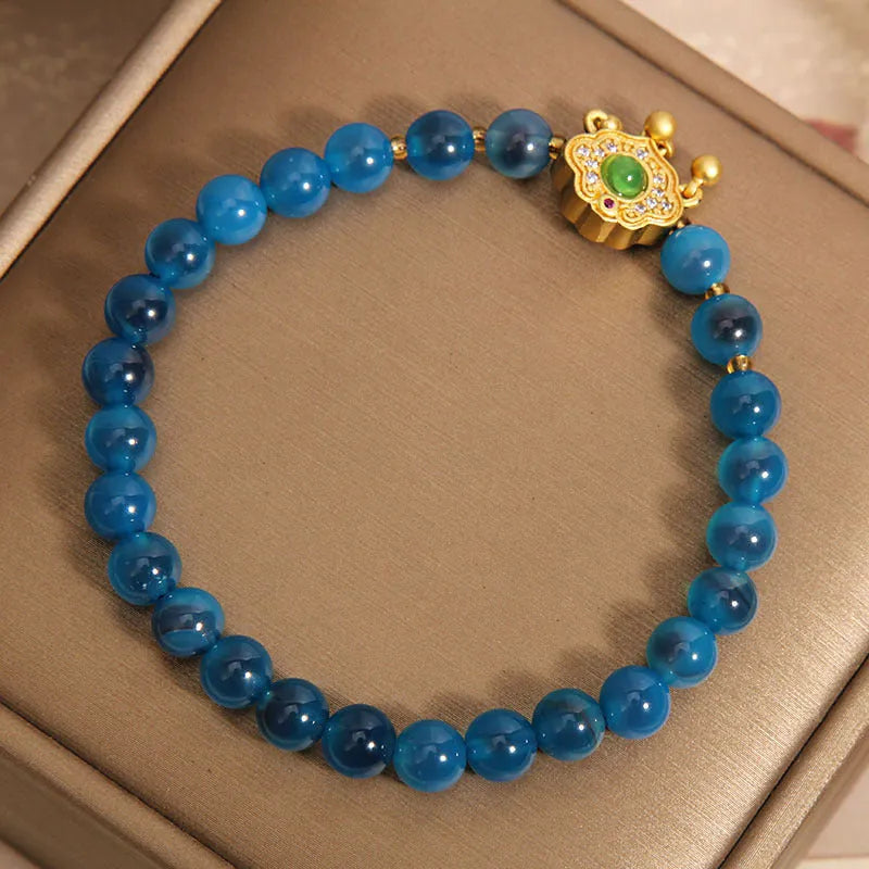 Blue agate safety lock pendant on a crystal women's bracelet with rhinestone details.