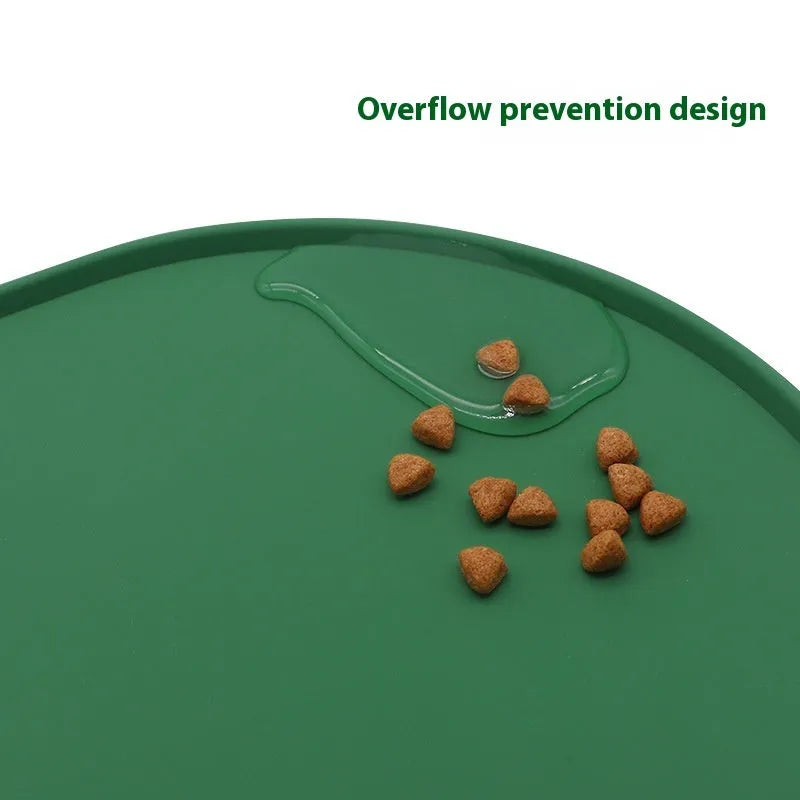 A green silicone placemat for cat food and water bowls on a wooden floor.