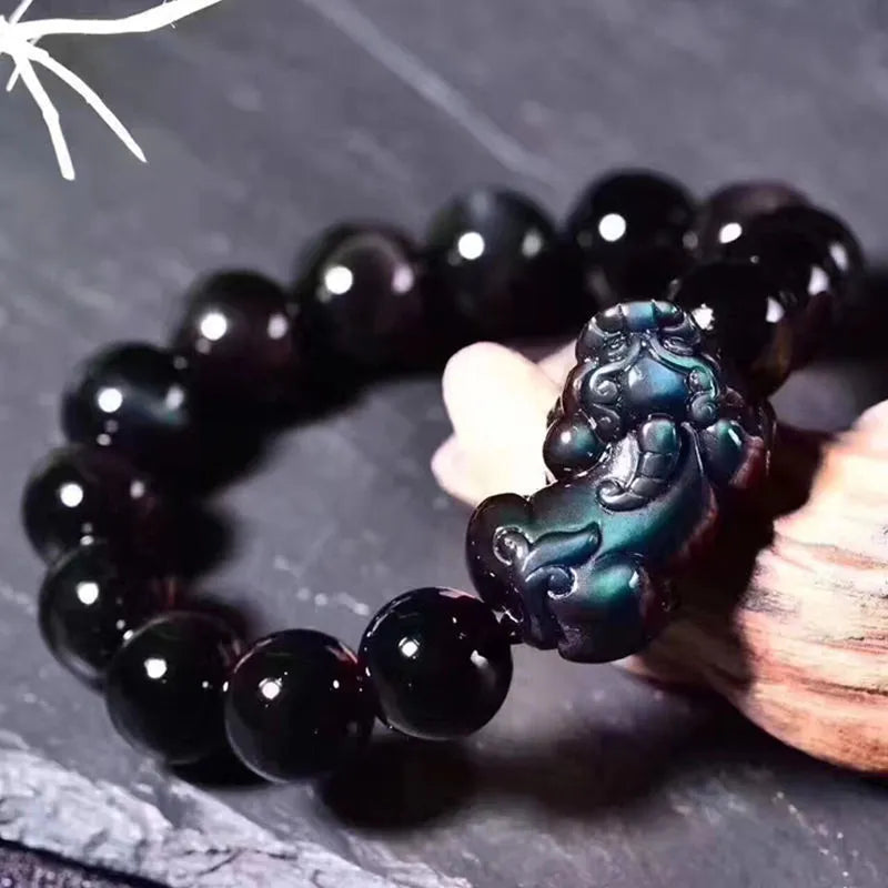 Natural ice colour Eye Obsidian crystal beaded bracelet on a wrist, showing clear spherical beads.