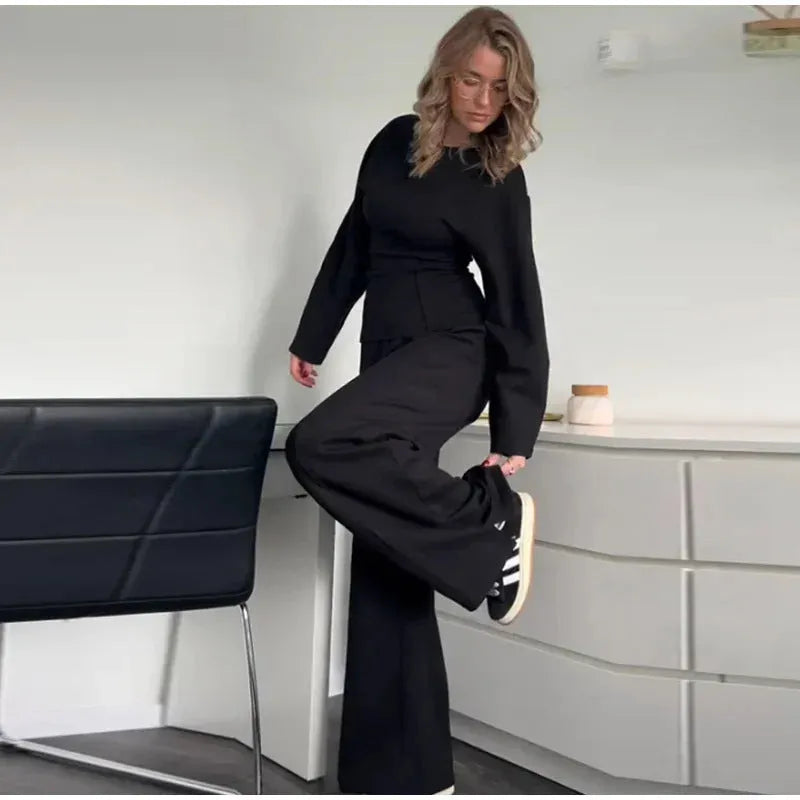Women's black polyester fleece long sleeve top and wide leg pants two-piece suit set with pockets.