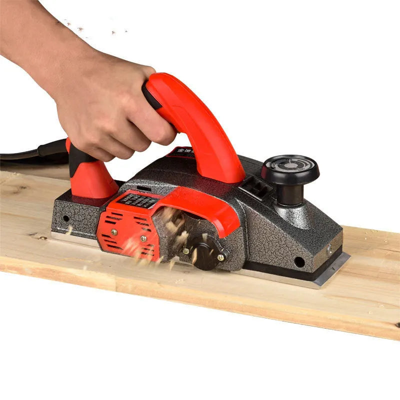 Red aluminium shell electric wood planer with 82mm cutting width on workbench