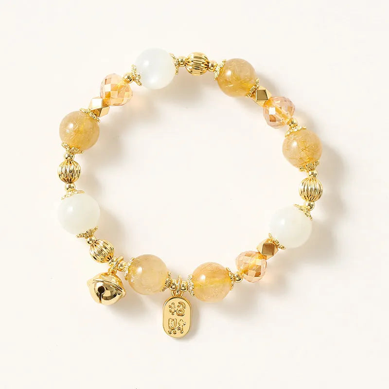 Gold electroplated bracelet with rutilated quartz and a ringing bell charm