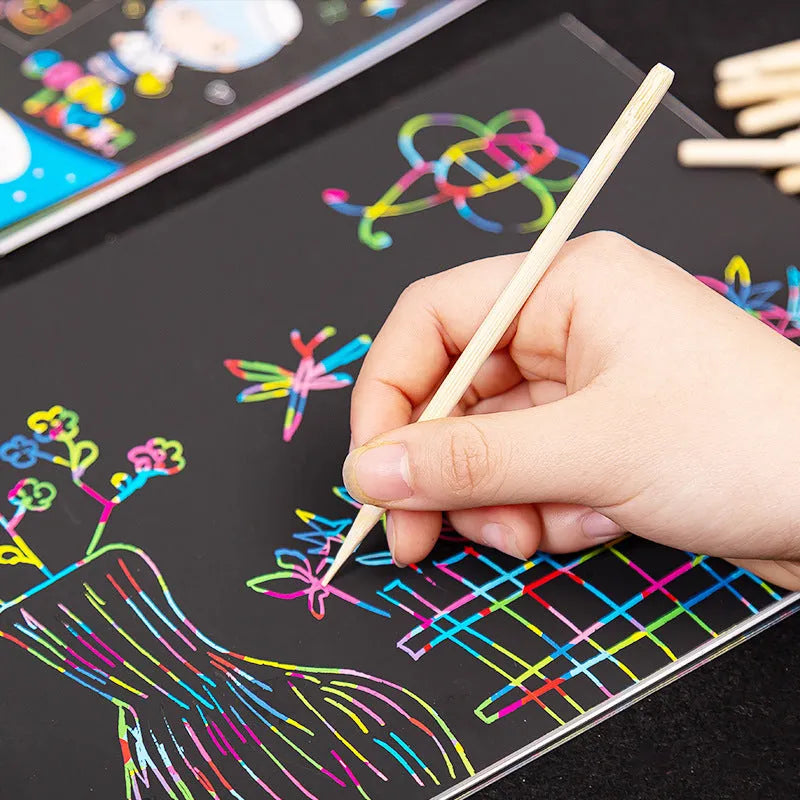 Scratch art repair tool set with scraping pen, liquid solution, brushes, and bamboo sticks on a craft table.