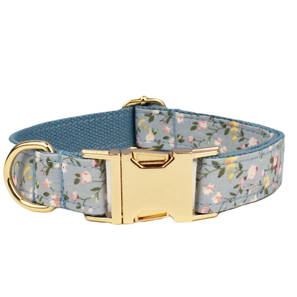Blue floral pattern dog collar with matching leash, bow tie, vest and waste bag accessories on white background
