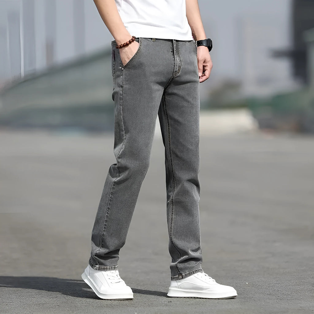 Man wearing smoky grey straight leg jeans with low waist and zipper fly.