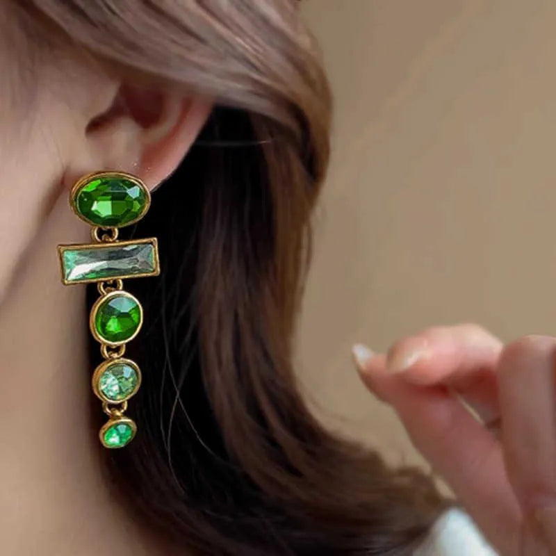 A pair of green gradient alloy earrings with geometric shapes, inlaid zircon stones, and decorative tassels.