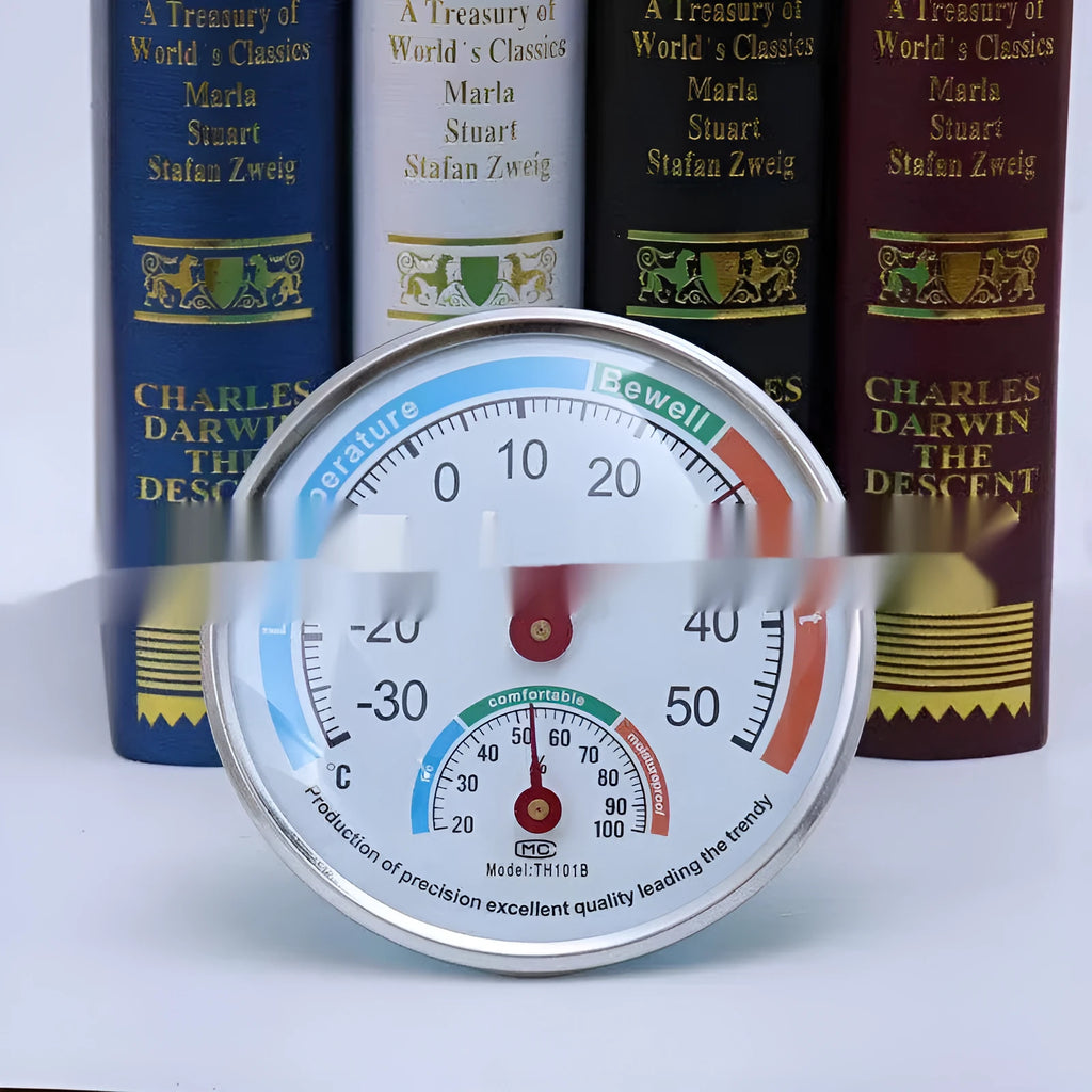Indoor wall thermometer with plastic black shell and black plastic pointer on a wall