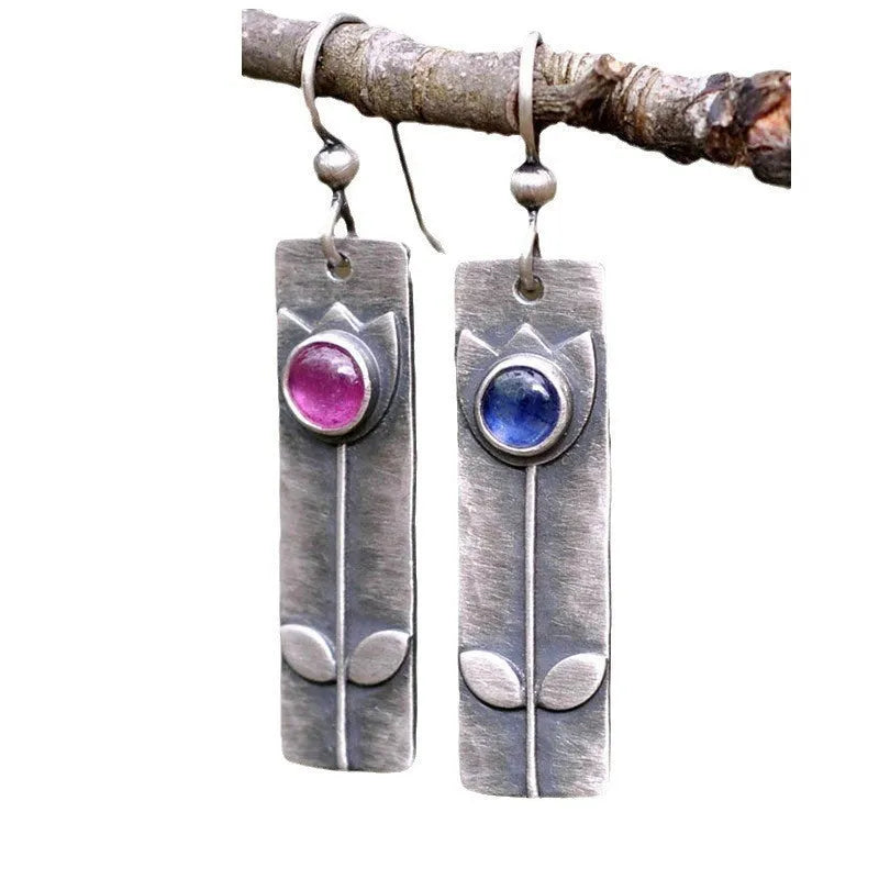 Antique finish red sapphire earrings with a geometric ellipse shape on electroplated metal.