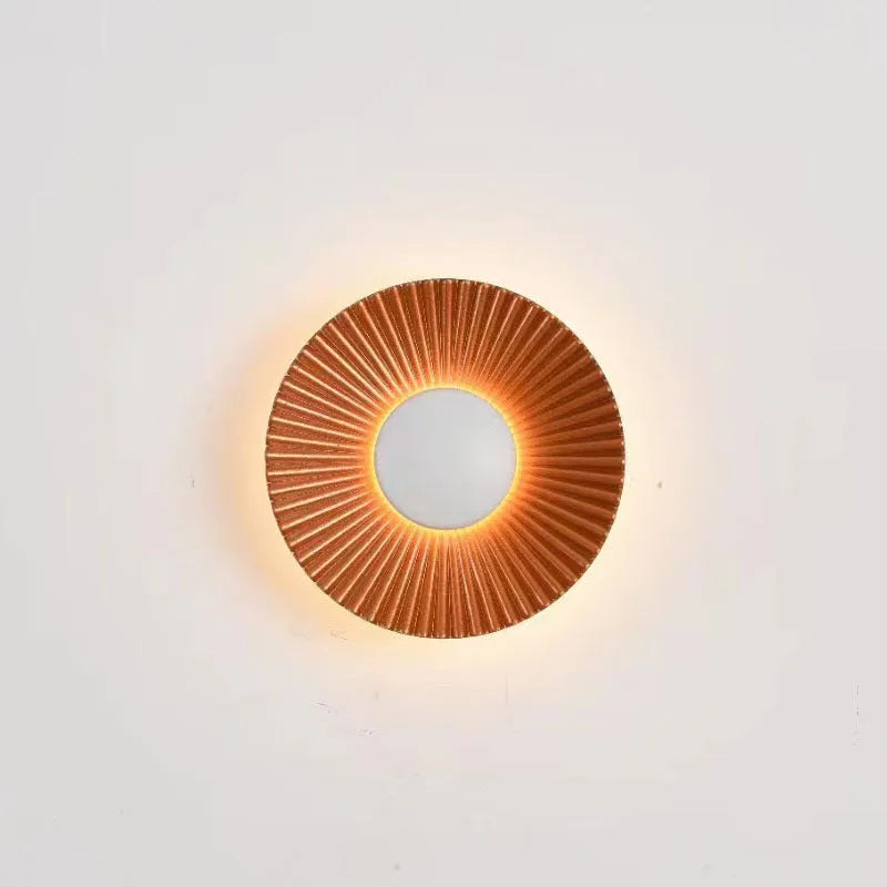 Round wall lamp with aluminium shade in a two-tone white and gold colour combination, mounted on a plain wall.