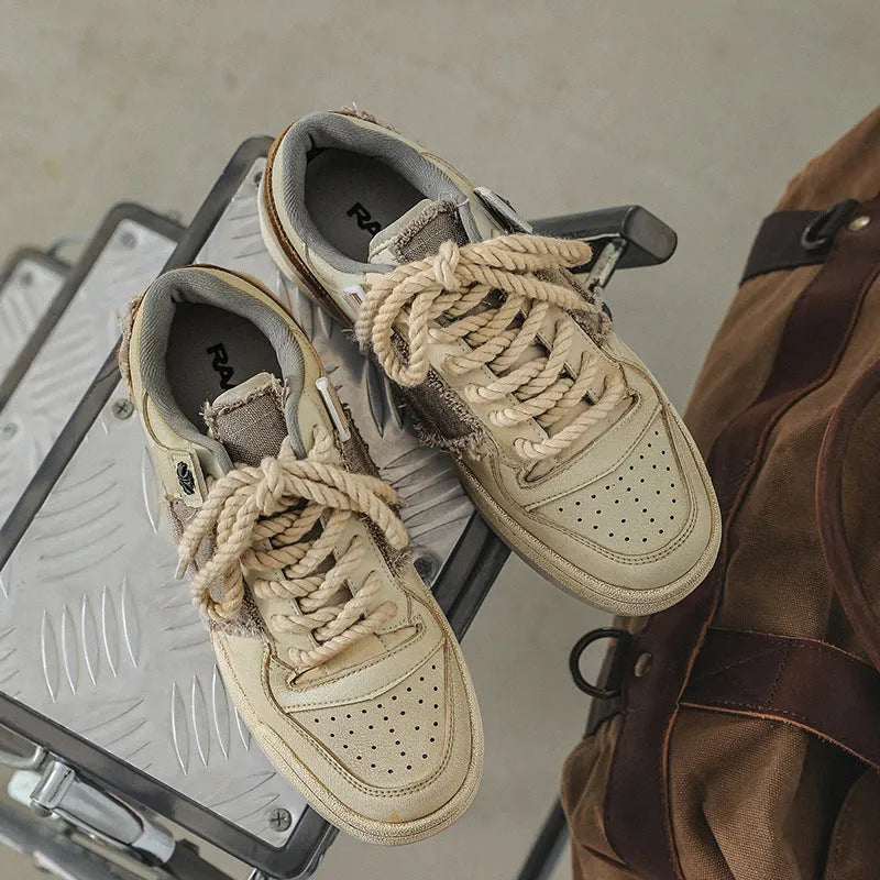 Beige low-top vintage skate shoes with lace-up front and rubber sole.