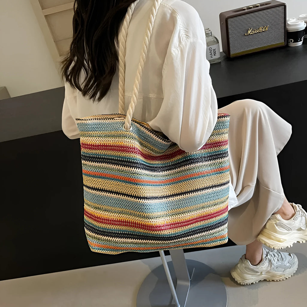 Blue woven nylon shoulder bag with an adjustable strap shown on a model.