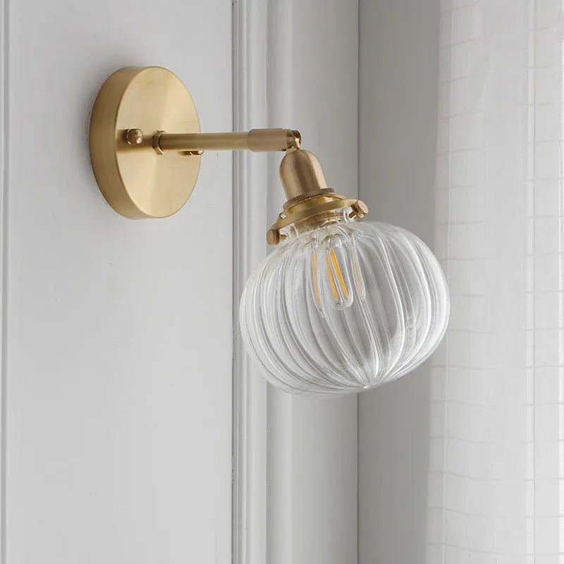 Pumpkin shaped transparent glass wall lamp with water ripple texture mounted on a wall
