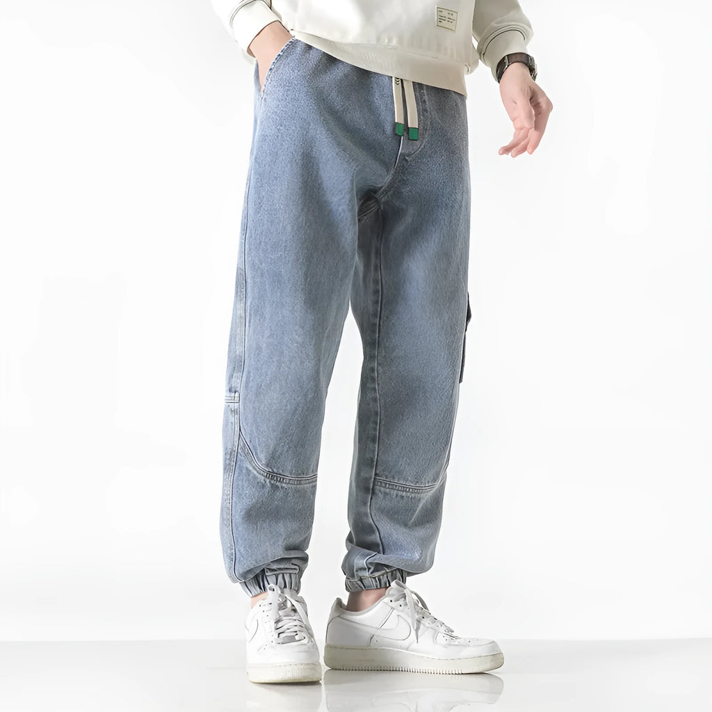 Men's loose-fit tapered cotton trousers in black, shown in a casual setting.