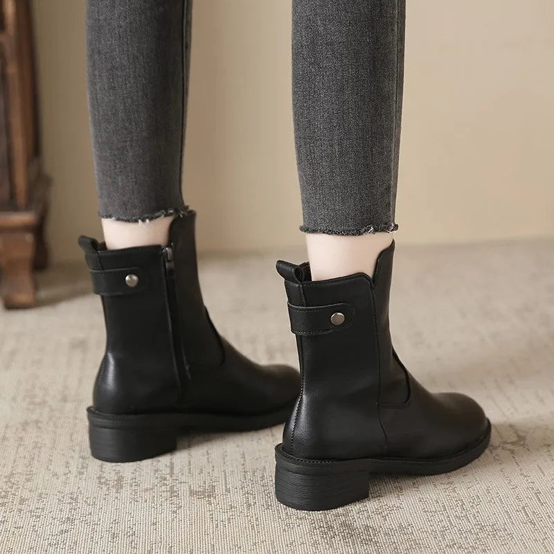 Black women's ankle boots with a side zipper, round toe, and a low rubber sole