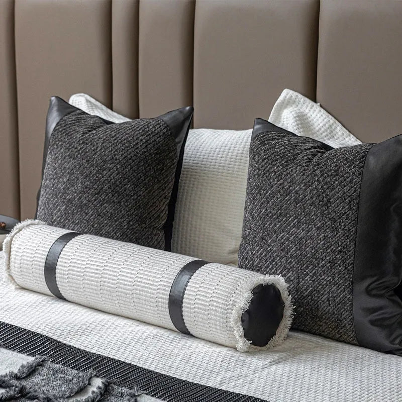 Modern minimalist bedding set with grey and white plaid blanket, pillowcase, and round pillow on bed