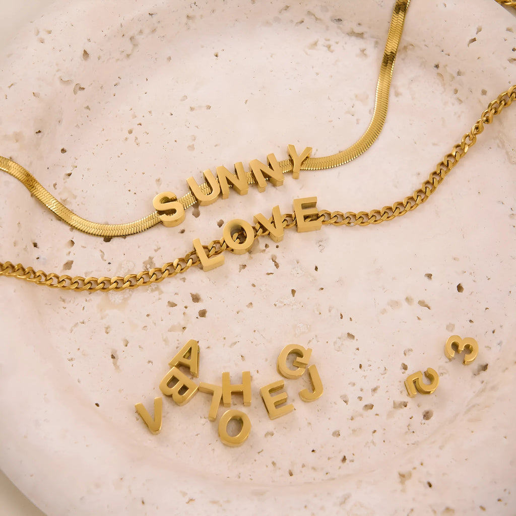 Titanium steel necklace with a choice of letter, number, or love heart pendant on a 40.5 cm chain.