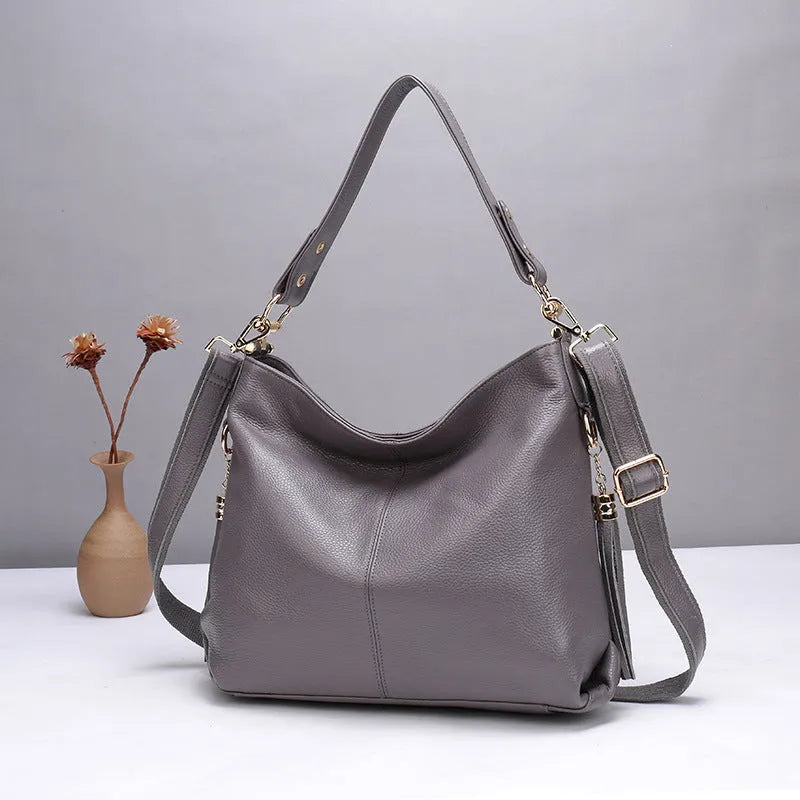 Genuine leather vertical square crossbody bag in black colour with visible stitching and multiple compartments.