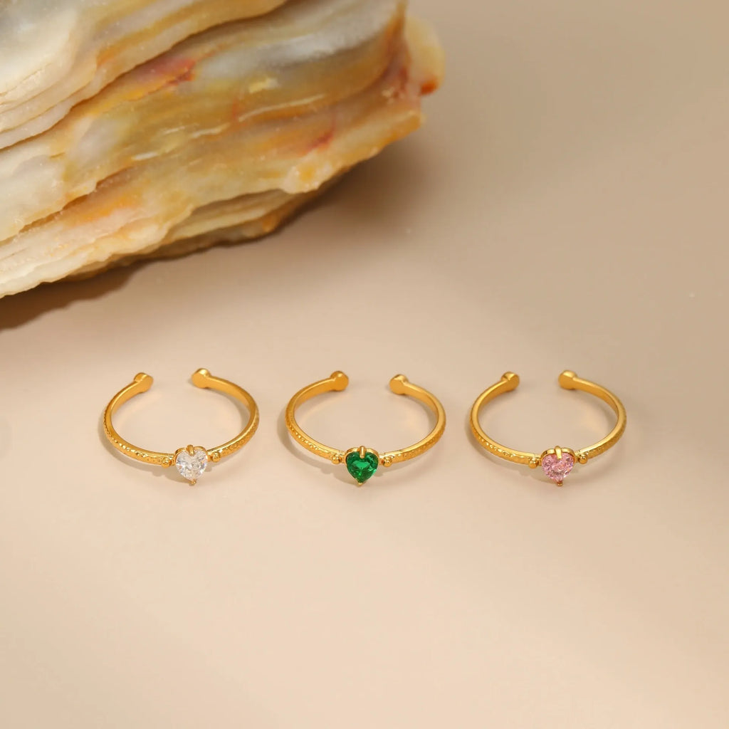 Open-ended stainless steel ring with a heart-shaped green zircon stone inlay on a geometric band.