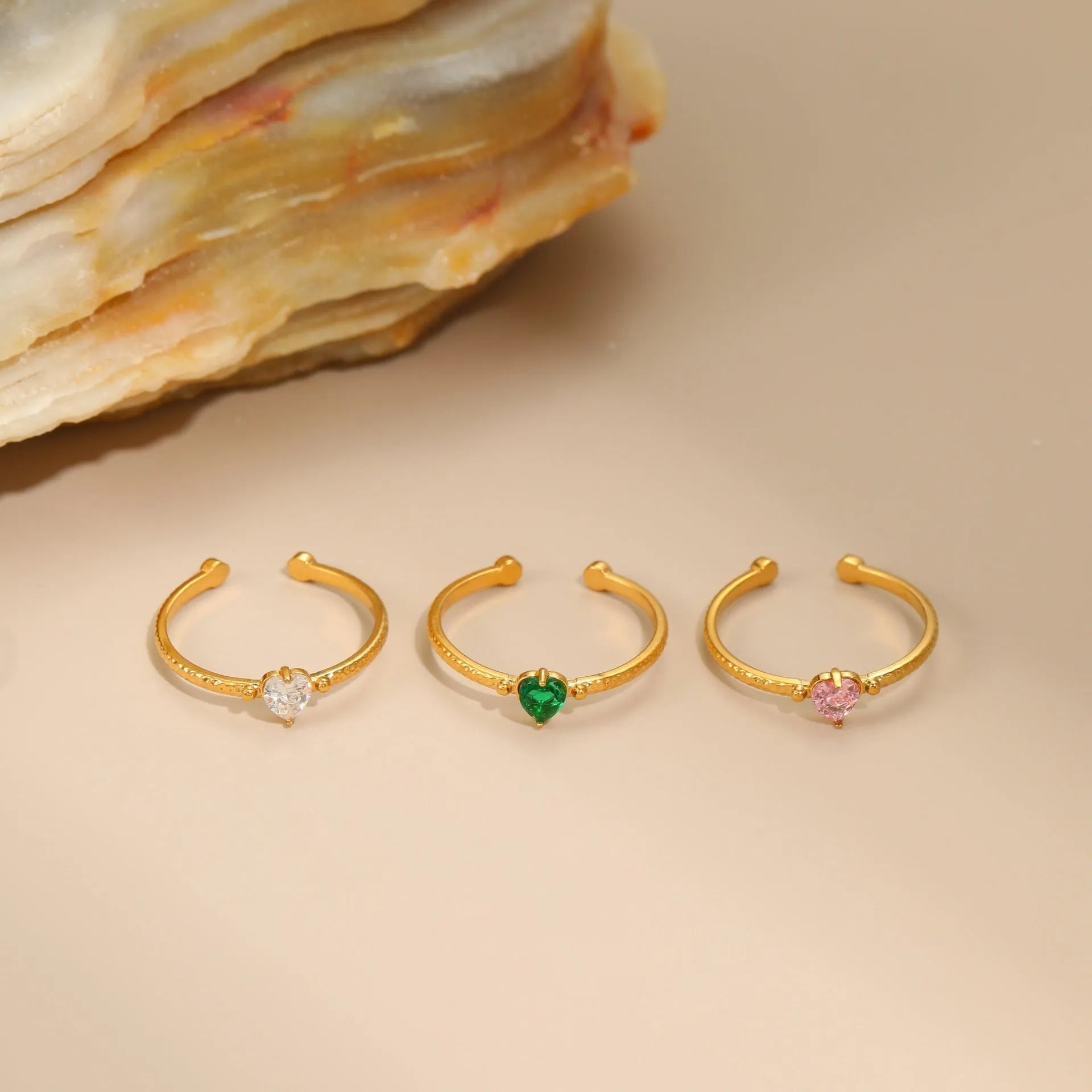 Open-ended stainless steel ring with a heart-shaped green zircon stone inlay on a geometric band.
