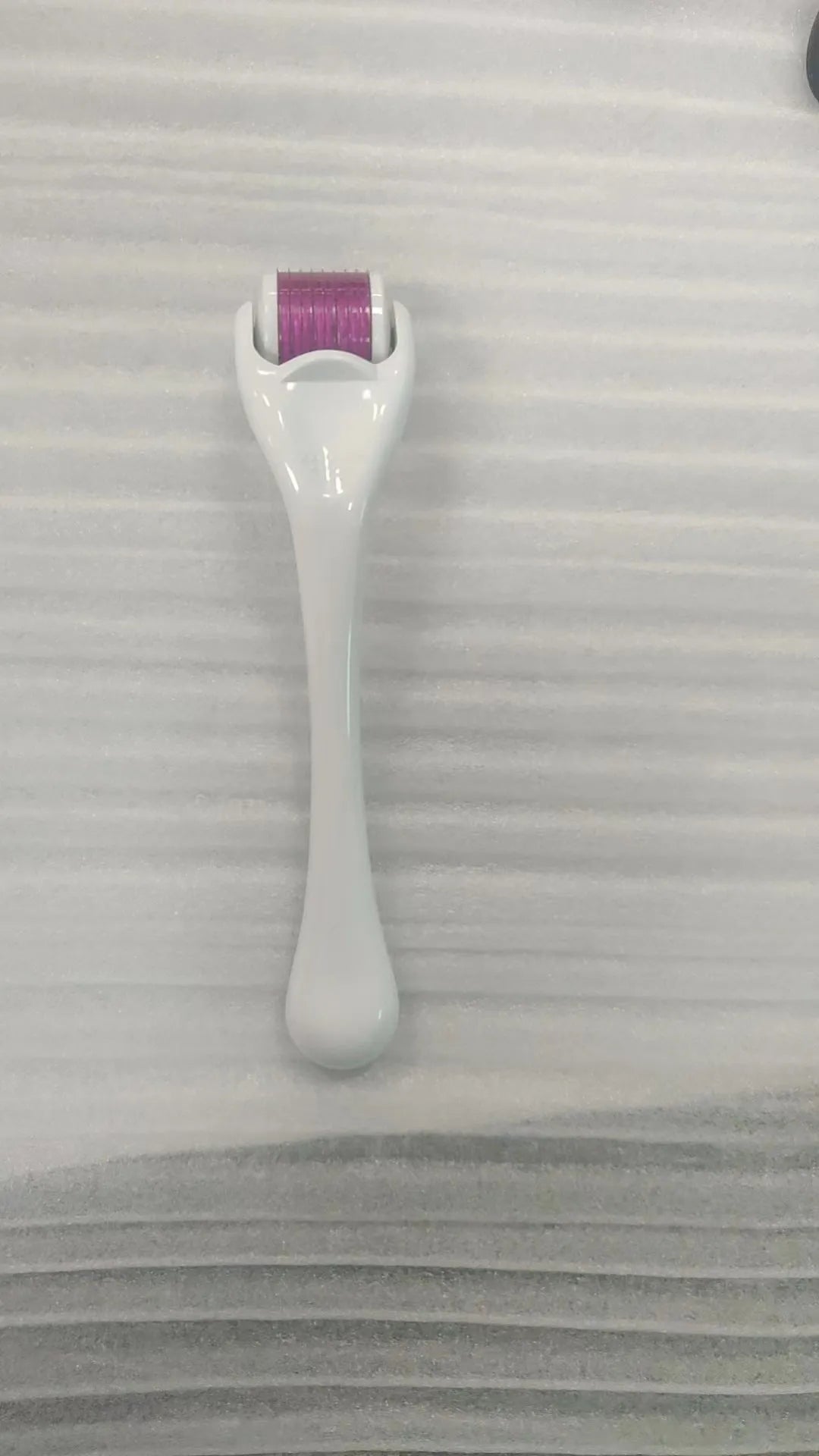 Black handle microneedle roller with purple wheel showing 540 needles, next to white and blue handle options.