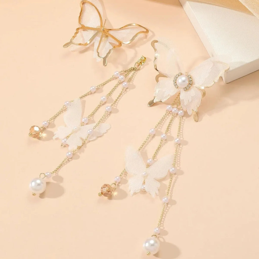 A pair of white butterfly-design earrings with pearl and rhinestone details on a tassel lace style.