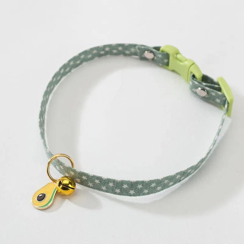 Adjustable green pet collar with a metal bell and pink bow tie on a small dog.