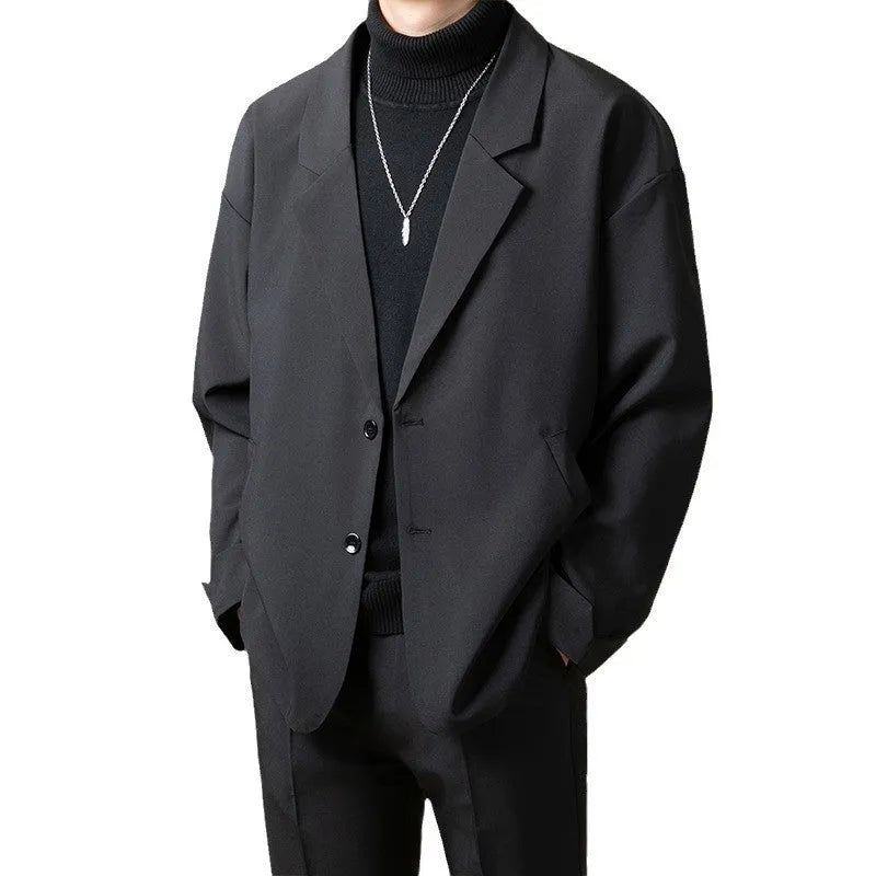 Man wearing a loose-fit apricot coloured suit jacket with long sleeves.