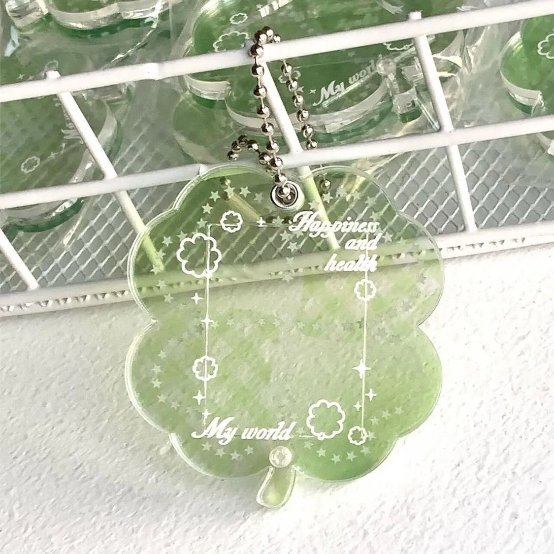 Acrylic four-leaf clover pendant keychain for phones in blue, green, and mint colour options.