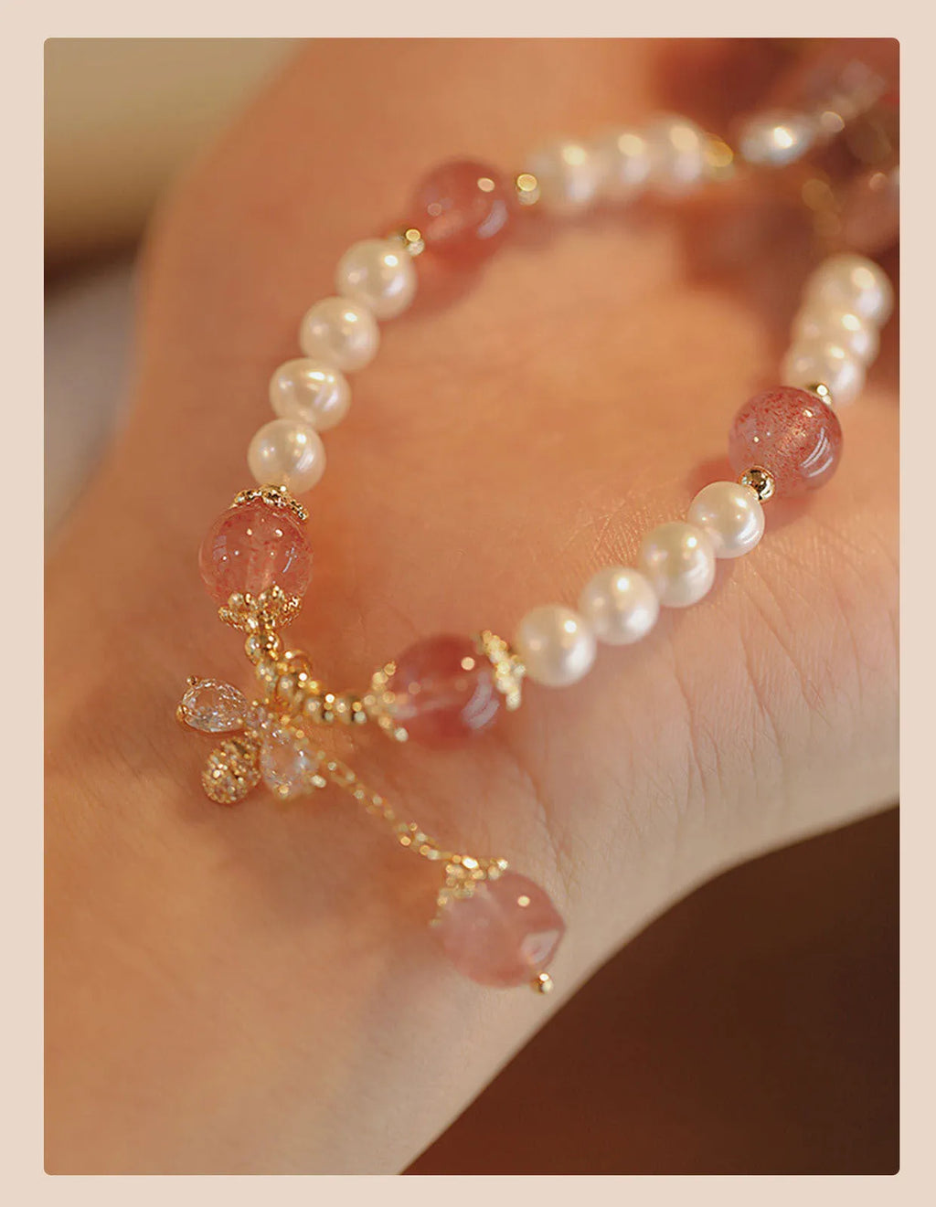 Women's hand-made strawberry quartz crystal bracelet with stringed pearls and bow detail