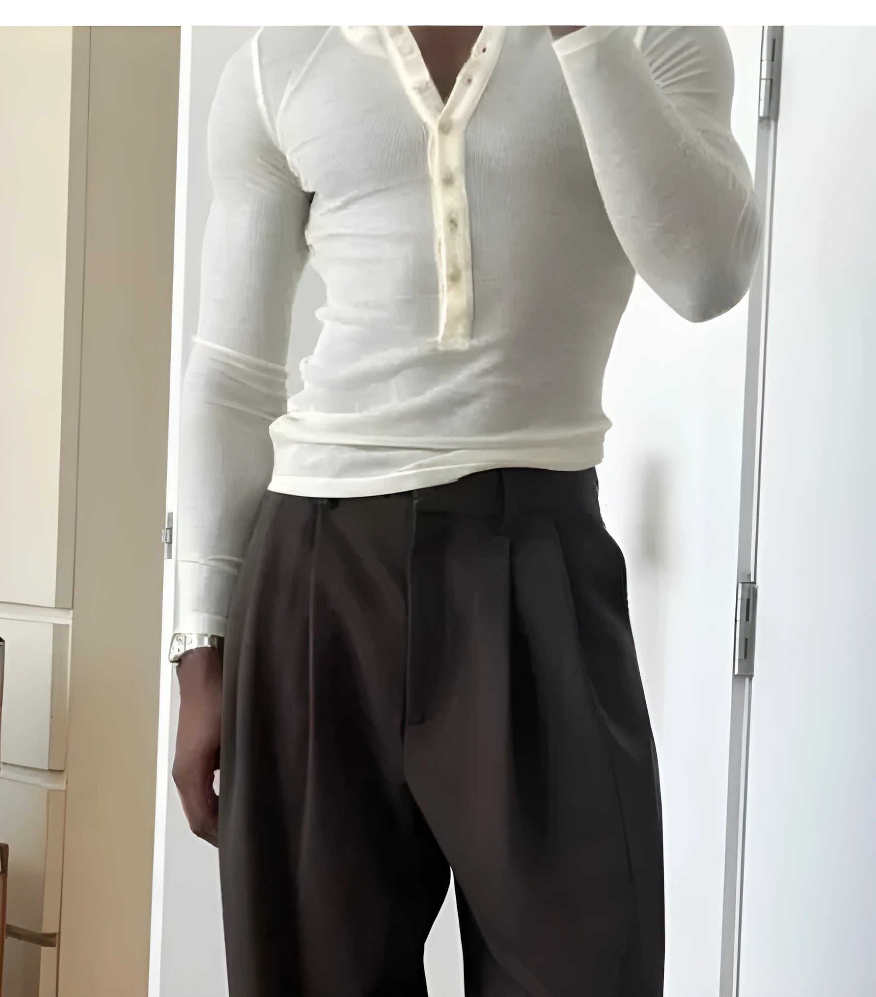 Man wearing a cream-coloured ribbed long-sleeve henley top with button detail.